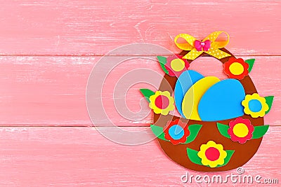 Easter basket with eggs and flowers made of cardboard, on pink wooden background, with space for congratulation to Easter Stock Photo