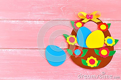 Easter basket with eggs and flowers made of cardboard, on pink wooden background, with space for congratulation to Easter Stock Photo