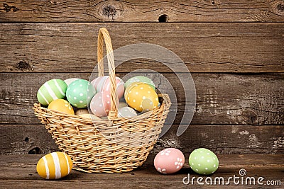 Easter basket filled eggs over rustic wood Stock Photo