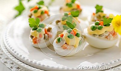 Easter boiled eggs stuffed with traditional vegetable salad with mayonnaise served on a white plate Stock Photo