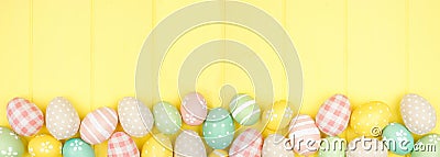 Easter bottom border with modern farmhouse cloth and pastel eggs over a yellow wood banner background Stock Photo