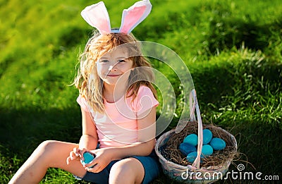 Easter egg hunt. Easter bunny child boy with cute face. Kids hunting easter eggs. Cute child with easter basket on grass Stock Photo