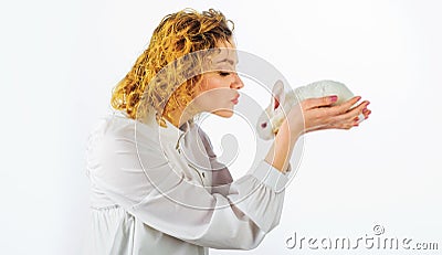 Easter Bunny. Happy woman with white rabbit. Beautiful girl kisses furry baby hare. Stock Photo