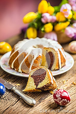 Easter Cake. Traditional ring marble cake withe easter decotation. Easter eggs and spring tulips. Stock Photo