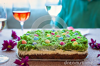 Easter cheesecake decorated with little colourful sweet eggs on top of green moss like layer. Stock Photo
