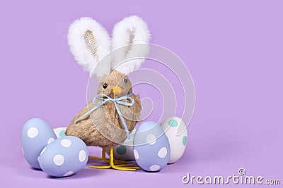 Easter chick with bunny ears and pastel Easter eggs Stock Photo