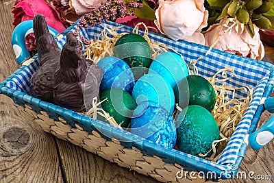 Easter colored eggs, straw, flowers Stock Photo