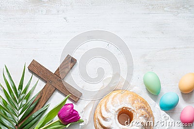 Easter colorful spring tulips with palm cross cake and eggs decoration on white wooden natural background Stock Photo