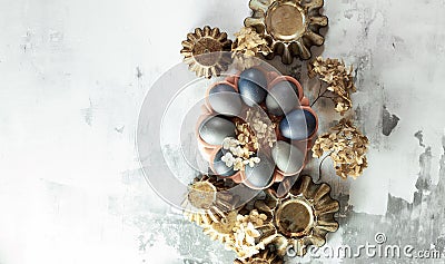 Easter composition from blue eggs, cake forms, dry flowers on concrete background Stock Photo