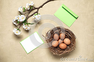 Easter composition. Brown eggs, cherry blossom branch artificial and mockup blank greeting card. Concrete background. Top view, Stock Photo