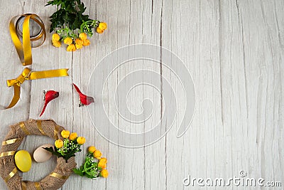 Blank for a wreath, colorful eggs, cute red birds, yellow flowers, ribbons and a bow on a wooden background. Stock Photo