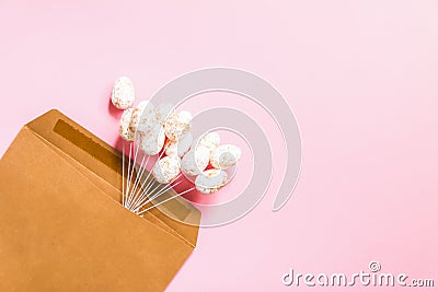 Easter composition with traditional decor. Small decorative eggs in craft paper envelopwe on light background Stock Photo