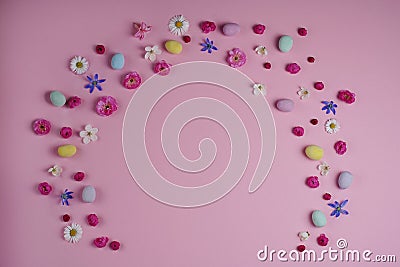 Easter concept. Top view of colorful easter eggs spring flowers on pink background with blank space Stock Photo