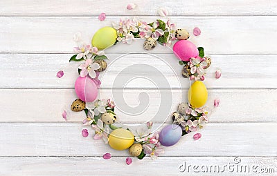 Easter decoration. Circle Easter frame of pink flowers apple tree, colored easter eggs and quail eggs Stock Photo