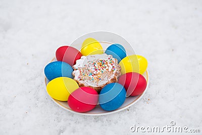 Easter decoration from colored eggs and Easter cake on a white plate Stock Photo