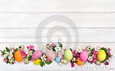 Easter decoration. Pink flowers apple tree and colored easter eggs and quail eggs on background of white painted wooden planks Stock Photo