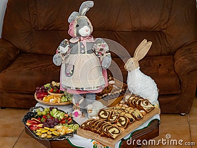 Easter decoration with rabbits and plates with tasty cake and fruit Stock Photo