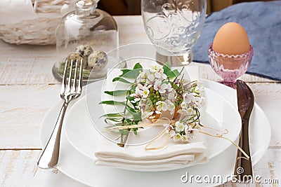 Easter decoration table setting, white plates, napkin, flowers in eggshell Stock Photo