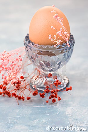 Easter egg in crystal cup, spring red and pink small flowers, decoration,table setting Stock Photo