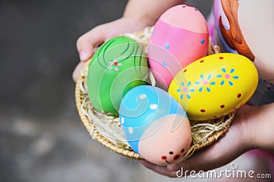 Easter egg hunt colorful in basket on hand little girl Egg painted in the nest Stock Photo