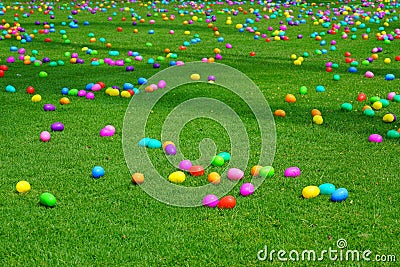 An Easter egg hunt with plastic eggs on a green lawn Stock Photo