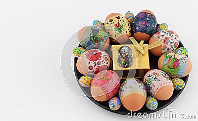 Easter eggs, chocolate bunny, and giftbox on black plate Stock Photo