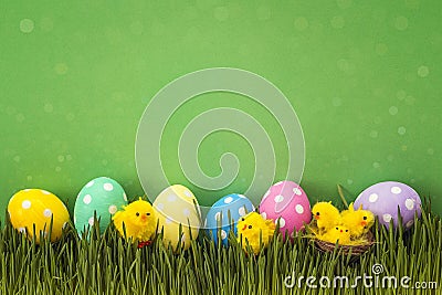 Easter eggs with decorative chicken in fresh grass on green back Stock Photo