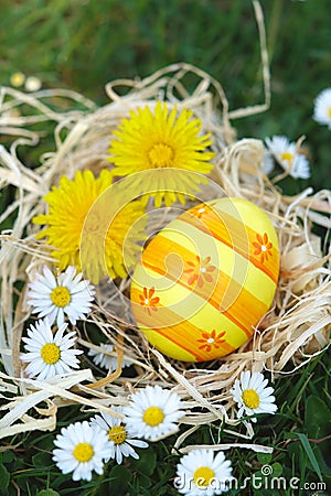 Easter eggs on the meadow with daisies and dandelions Stock Photo