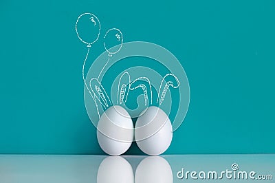 Easter eggs painted with ears and balloons on the blue background Stock Photo