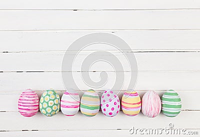 Easter eggs painted in pastel colors on a white wood Stock Photo
