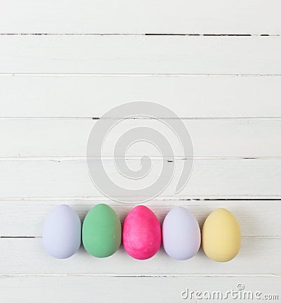 Easter eggs painted in pastel colors on white wood Stock Photo