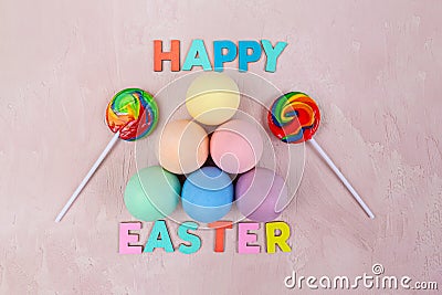 Easter eggs painted in plain colors and lollies with Happy Easter text. Stock Photo
