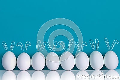 Easter eggs painted with rabbits ears and ballooons on the blue background Stock Photo