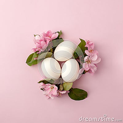 Easter eggs and pink flowers on white background. Easter nest. Flat lay, top view, concept of spring, femininity and beauty. Stock Photo