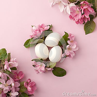 Easter eggs and pink flowers on white background. Easter nest. Flat lay, top view, concept of spring, femininity and beauty. Stock Photo