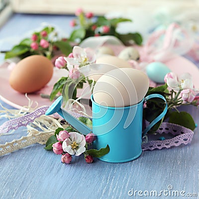 Easter eggs, spring flowers and lace ribbons on a wooden table Stock Photo