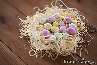 Easter eggs in straw nest on wooden table Stock Photo