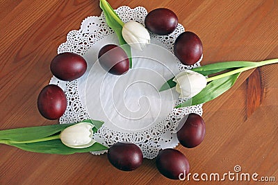 Easter eggs and white tulips on the table laid out in the shape of a heart Stock Photo