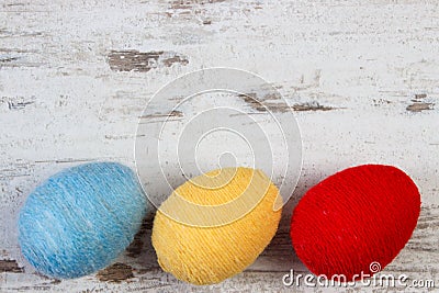 Easter eggs wrapped woolen string on wooden background, copy space for text, decoration for Easter Stock Photo