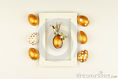 Easter festive decoration. Top view of easter eggs colored with golden paint and empty mock-up photo frame. Various dotted designs Stock Photo