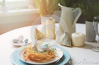 Easter scandinavian festive table with dining place decorated with nest Stock Photo