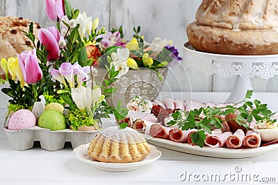 Easter festive table with food and spring floral arrangements Stock Photo