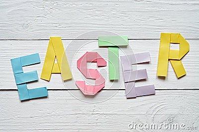 Easter folded paper origami colorful lettering on white wooden planks rustic background Stock Photo