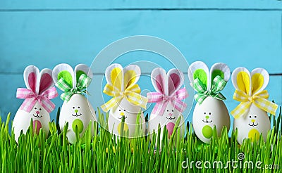 Easter funny bunny on green grass with easter eggs. Easter background. Stock Photo