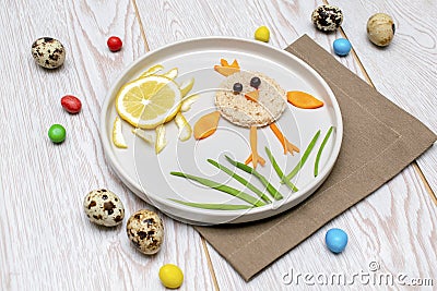 Easter funny creative healthy breakfast lunch food idea for kids, children. chicken shape sandwich from bread, peeled carrots, Stock Photo