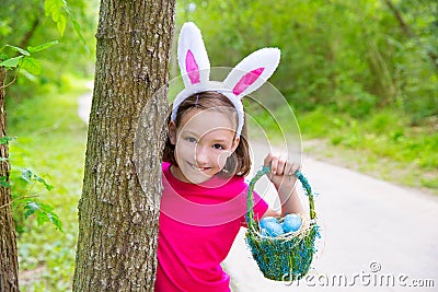 Easter girl with eggs basket and funny bunny face Stock Photo