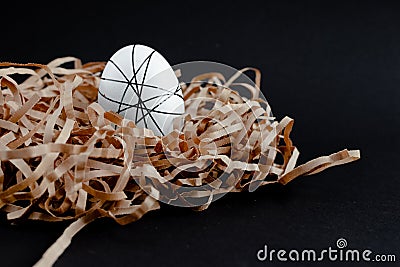 Easter goldenand white decorated eggs in nest on black background . Minimal easter concept copy space for text. Top Stock Photo