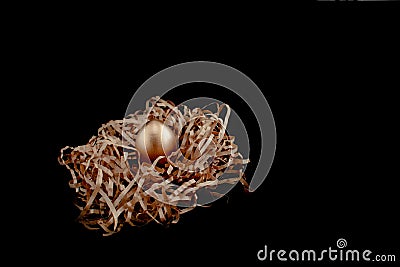 Easter goldenand white decorated eggs in nest on black background . Minimal easter concept copy space for text. Top Stock Photo