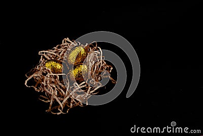 Easter goldenand white decorated eggs in nest on black background . Minimal easter concept copy space for text. Top Stock Photo