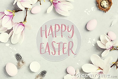 Easter greeting card with beautiful spring magnolia flowers and Easter decoration on grey stone background. Easter Stock Photo